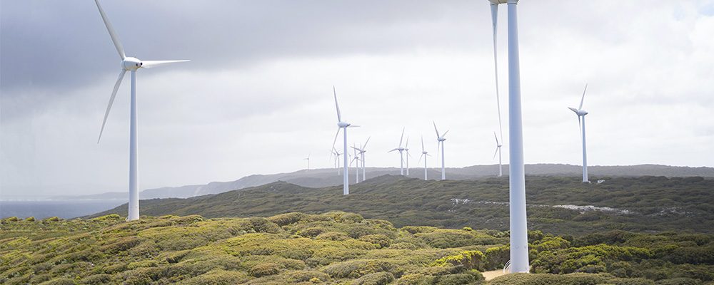 Imagen de turbinas eolicas en funcionamiento, capturada bajo un cielo nublado